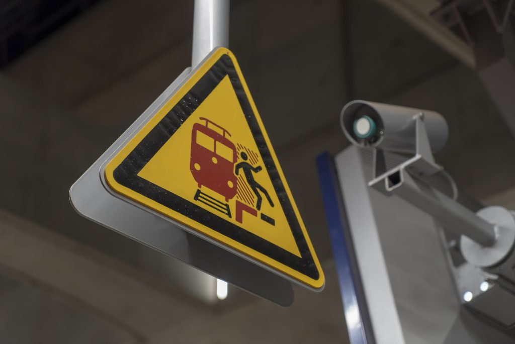Close-up shot of a yellow rail traffic sign with a camera in the background